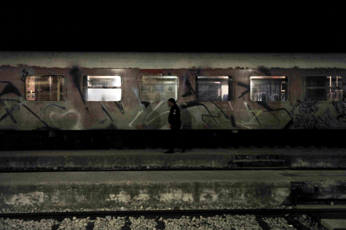 A Greek policeman patrols by a train at the railway station of Didymoteicho.