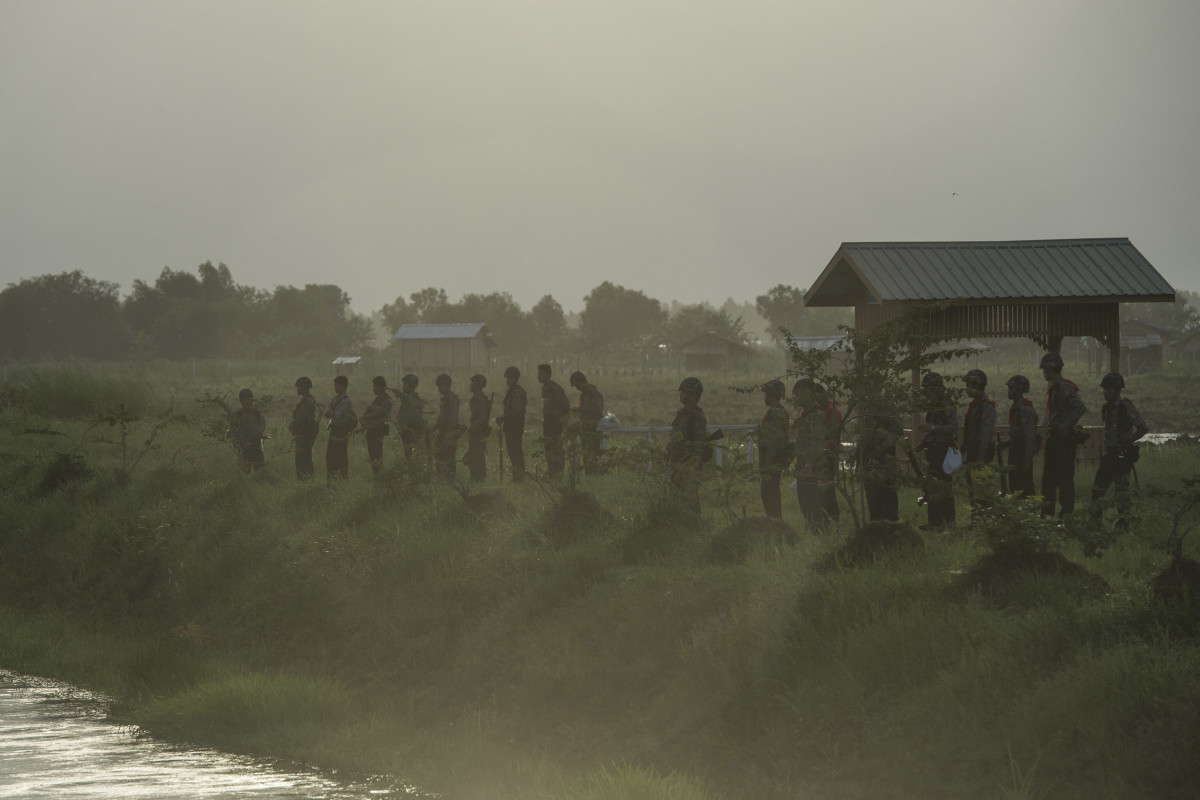The Myanmar Police Force stand guard by a slum near the outskirts of Yangon on June 12th, 2017.