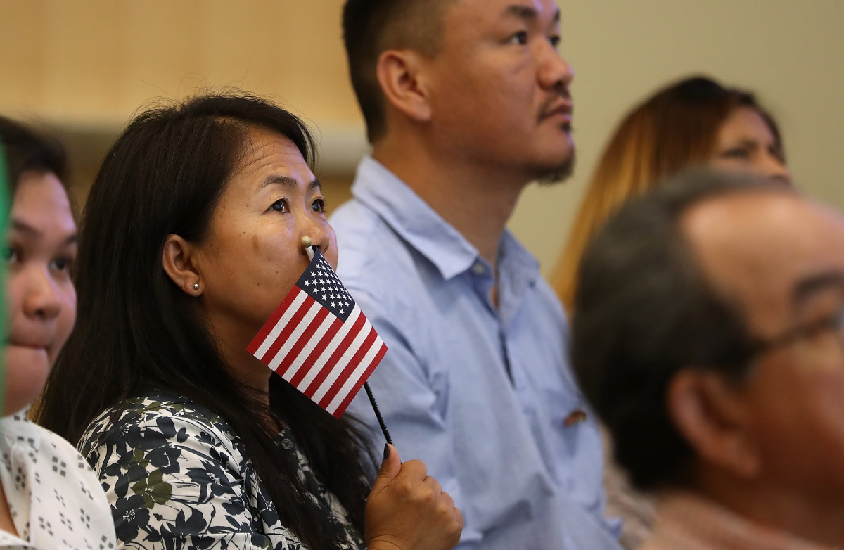 A newly naturalized citizen holds a U.S. flag after being sworn in as an American citizen during a naturalization ceremony on June 19th, 2017, in San Francisco, California. Twenty-nine former refugees from 17 different countries were sworn in during a ceremony to mark World Refugee Day, which falls on this date every year.