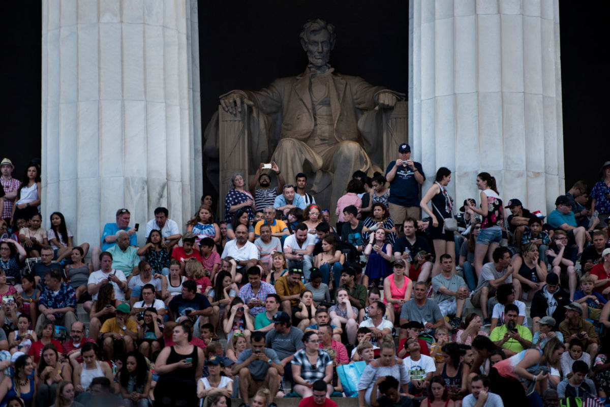People wait on the Lincoln Memorial for fireworks to celebrate Independence Day on July 4th, 2017, in Washington, D.C.