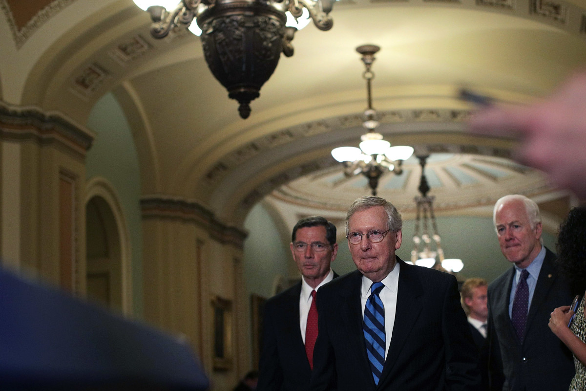 Senate Majority Leader Sen. Mitch McConnell (center) approaches the podium for a news briefing on July 11th, 2017, at the Capitol in Washington, D.C.