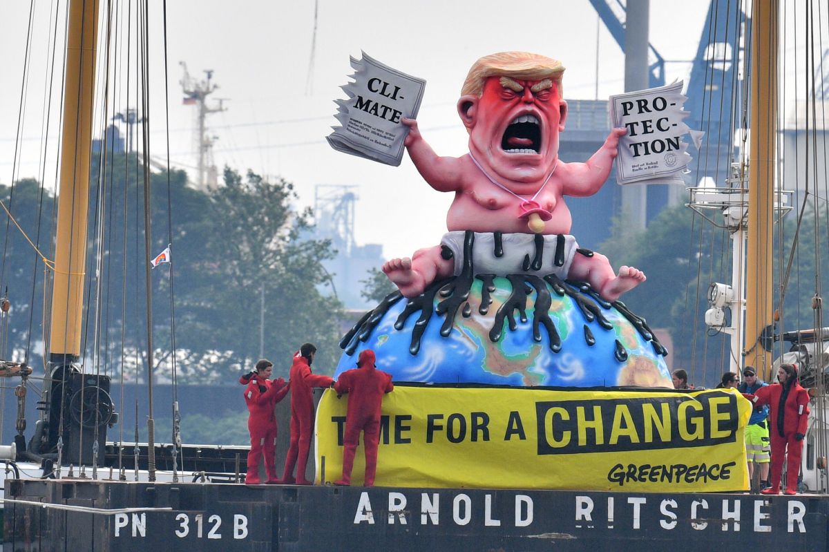 Greenpeace activists protest on a boat with a giant figure featuring President Donald Trump as a baby, tearing up a climate protection document, on July 7th, 2017, in Hamburg, Germany.