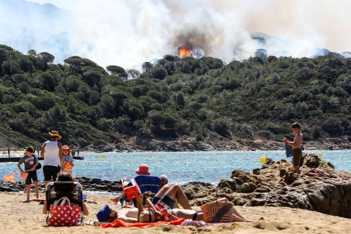 People enjoy the beach during a forest fire in La Croix-Valmer, France, on July 25th, 2017.