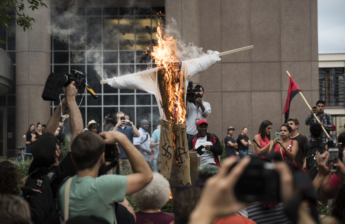 An effigy of U.S. President Donald Trump, dressed in khakis and a white shirt covered in swastikas, is set ablaze during a protest in Minneapolis, Minnesota, on August 14th, 2017.