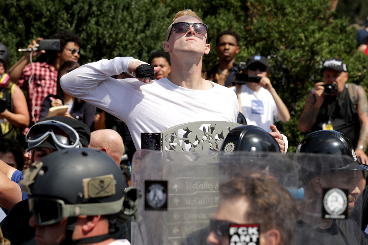 A man makes a slashing motion across his throat toward counter-protesters as he marches with other white nationalists and neo-Nazis during the Unite the Right rally on August 12th, 2017, in Charlottesville, Virginia.