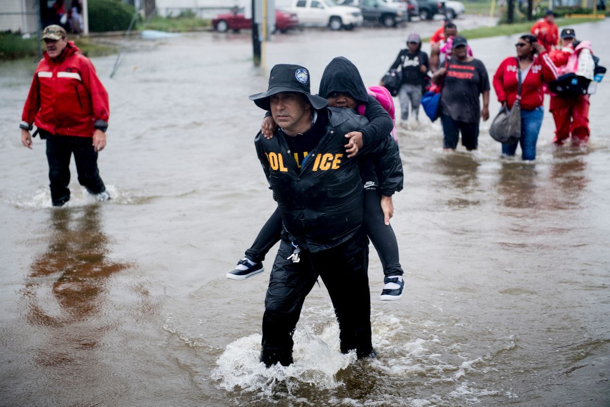 People walk to a Harris County Sheriff air boat while escaping a flooded neighborhood during the aftermath of Hurricane Harvey on August 29th, 2017, in Houston, Texas. Hurricane Harvey has set what forecasters believe is a new rainfall record for the continental United States, officials said Tuesday.
