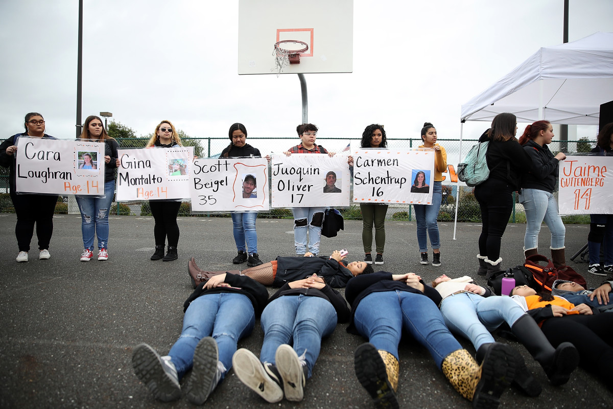 James Logan High School students hold signs honoring students killed at Marjory Stoneman Douglas High School as they observe a moment of silence during a walk out demonstration in Union City, California.