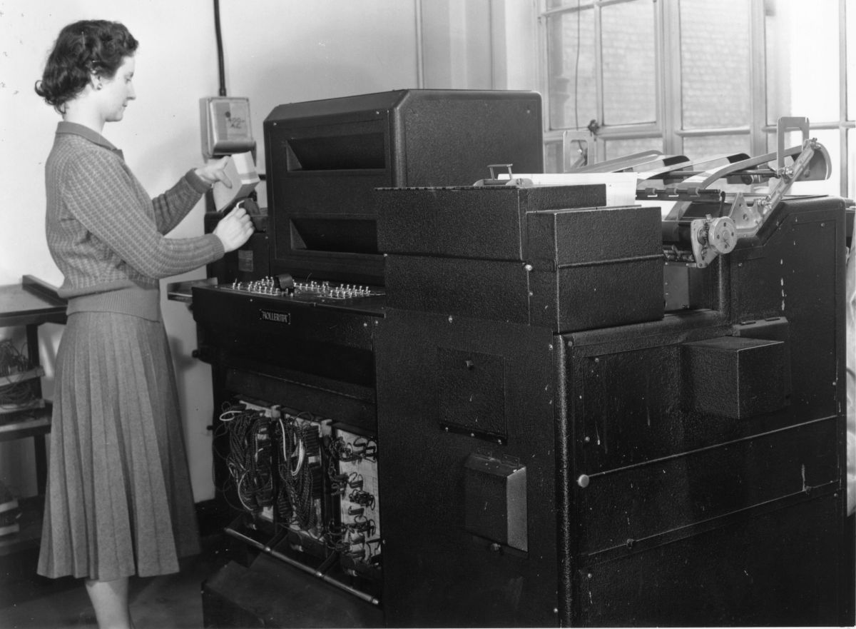 A woman operating a Hollerith Senior Rolling Total Tabulator in 1955.