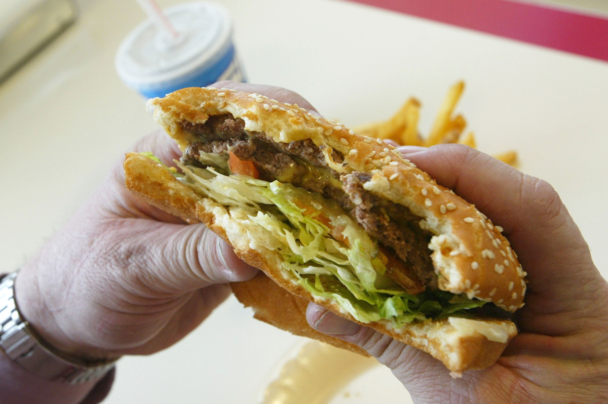 A man prepares to bite into a double cheeseburger at Majors Hamburgers, in Yakima, Washington.
