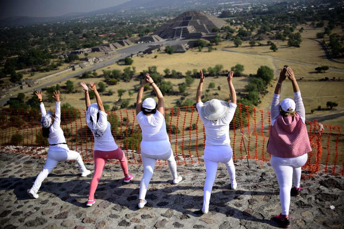 Women atop the Pyramid of the Sun at the archaeological site of Teotihuacan, Mexico, stretch and get energy from the rising sun during celebrations of the spring equinox on March 21st, 2018.