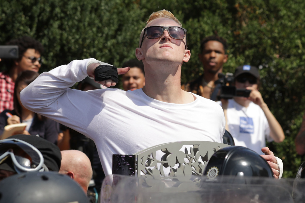 A man makes a slashing motion across his throat toward counter-protesters as he marches with other white nationalists, neo-Nazis, and members of the alt-right during the Unite the Right rally in Charlottesville, Virginia, on August 12th, 2017.