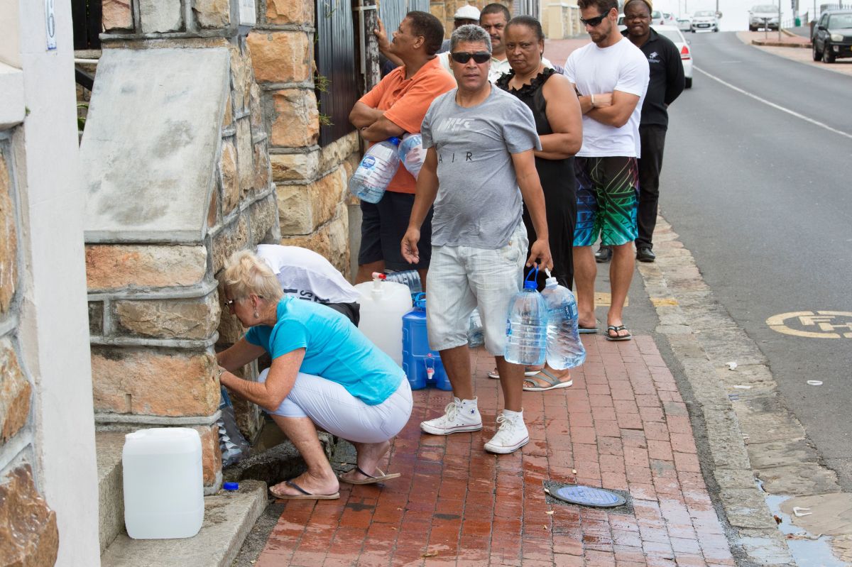 People collect drinking water from pipes fed by an underground spring, in St. James, about 25km from Cape Town's city center, on January 19th, 2018.