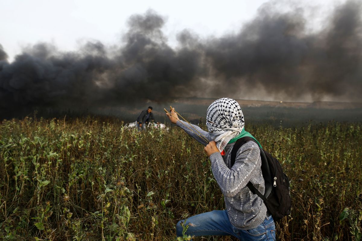 A Palestinian protester uses a slingshot to throw stones toward Israeli forces during clashes following a protest along the border with Israel, east of Gaza City, on April 5th, 2018. Palestinians readied for new protests along the Gaza border and Israel warned that its open-fire rules would not change as fears of fresh violence rose a week after the bloodiest day in years.