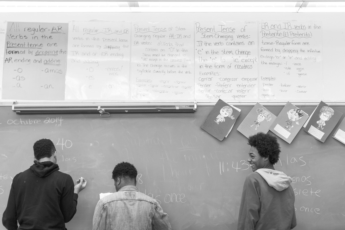 Junior Christopher Higgins, right, works at the chalkboard with other Normandy High School students. Research shows students of all races and incomes do worse in segregated schools.
