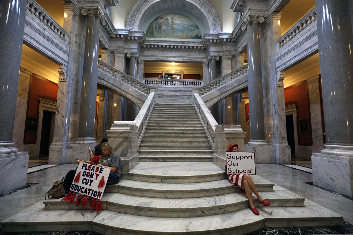Kentucky public school teachers sit outside the House chamber as they rally for a "day of action" at the Kentucky State Capitol to try to pressure legislators to override Kentucky Governor Matt Bevin's recent veto of the state's tax and budget bills on April 13th, 2018, in Frankfort, Kentucky.