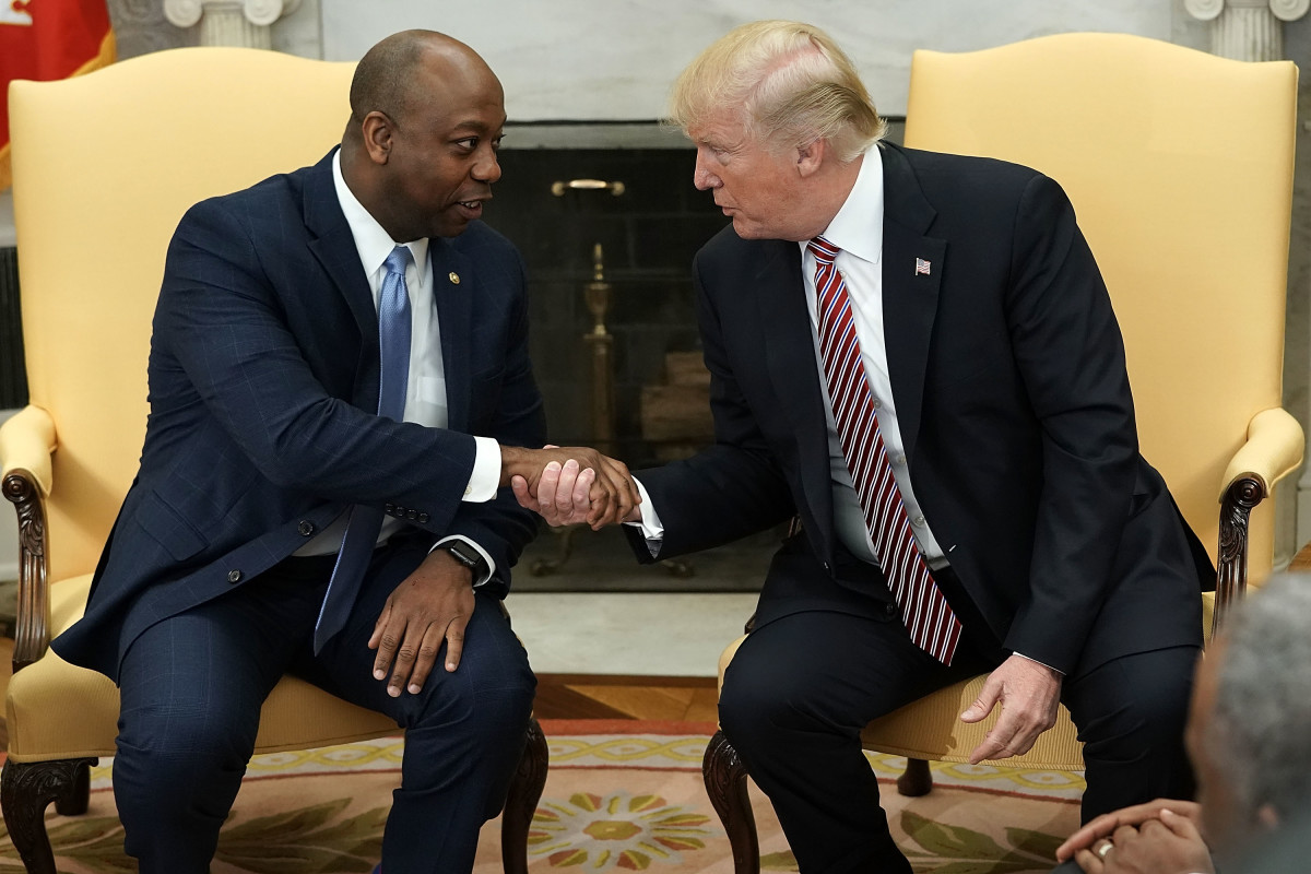 President Donald Trump shakes hands with Senator Tim Scott (R-South Carolina) during a working session regarding the Opportunity Zones provided by tax reform in the Oval Office of the White House on February 14th, 2018, in Washington, D.C.