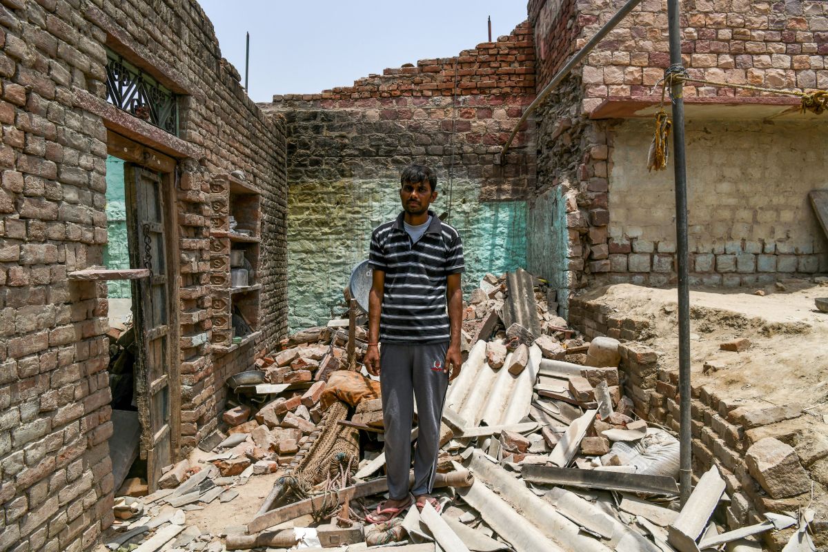 Surrender Kumar, 35, stands on the debris of his house caused by heavy storm winds in Kheragarh on the outskirts of Agra on May 4th, 2018. Kumar lost his 10-year-old son Vivek Kumar and his five-year-old nephew in the accident.