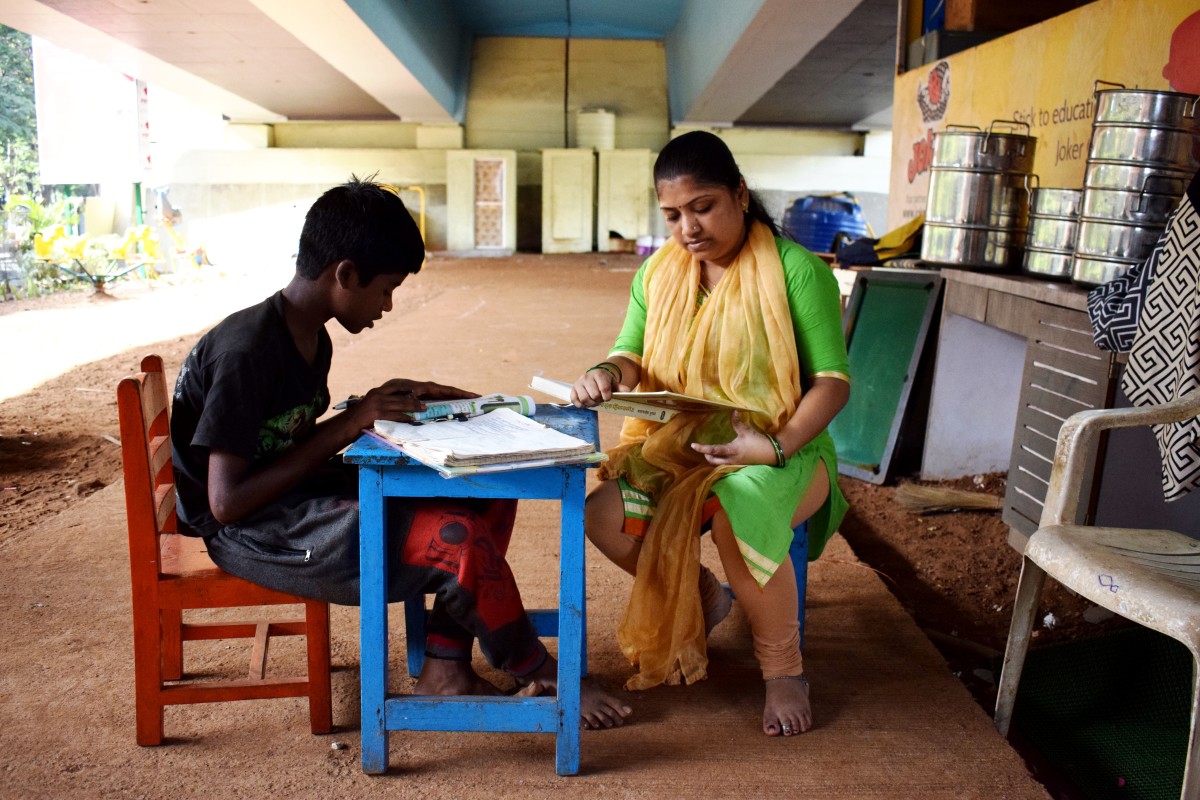 A teacher sits with Vishal Pawar at Signal School.