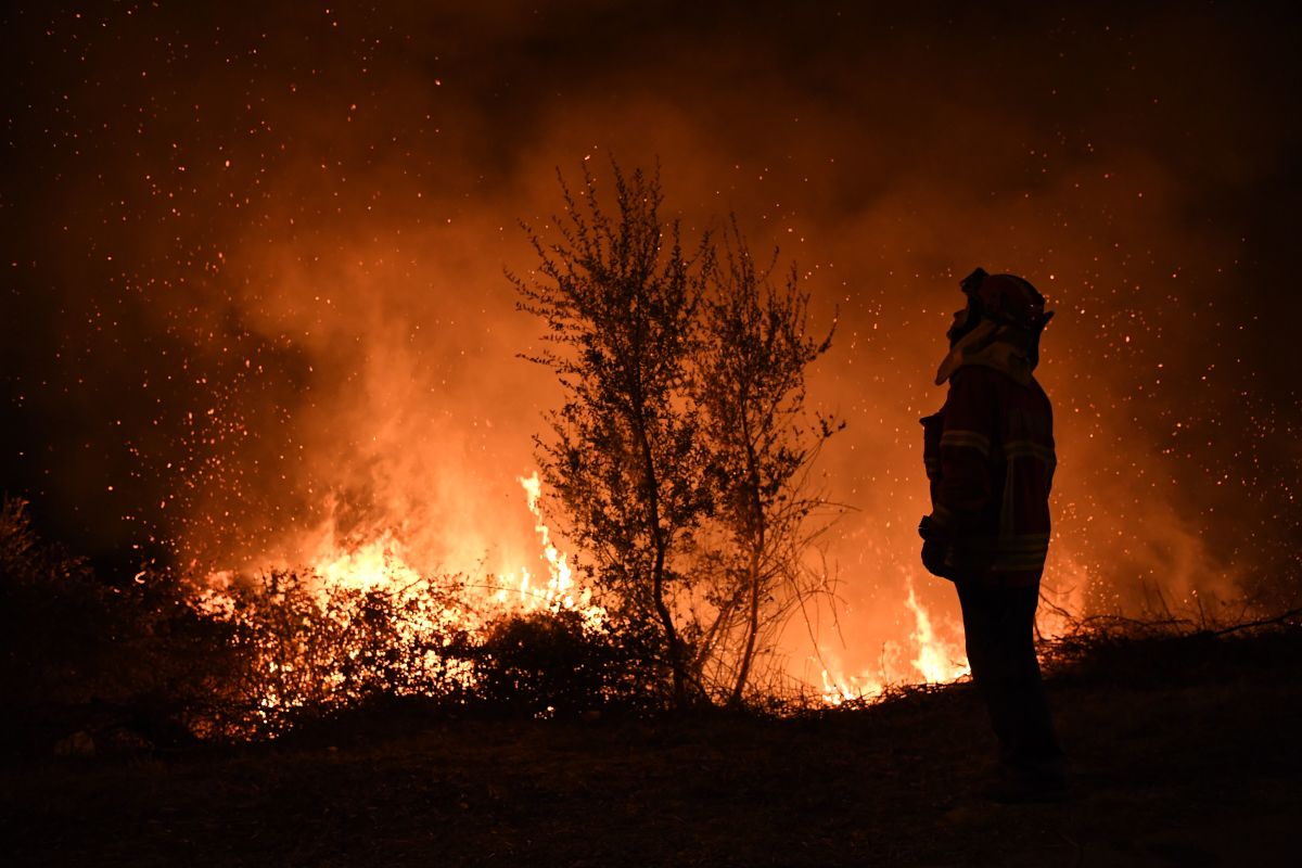 A firefighter observes the flames while trying to extinguish a fire in Cabanoes, Portugal, on October 16th, 2017.