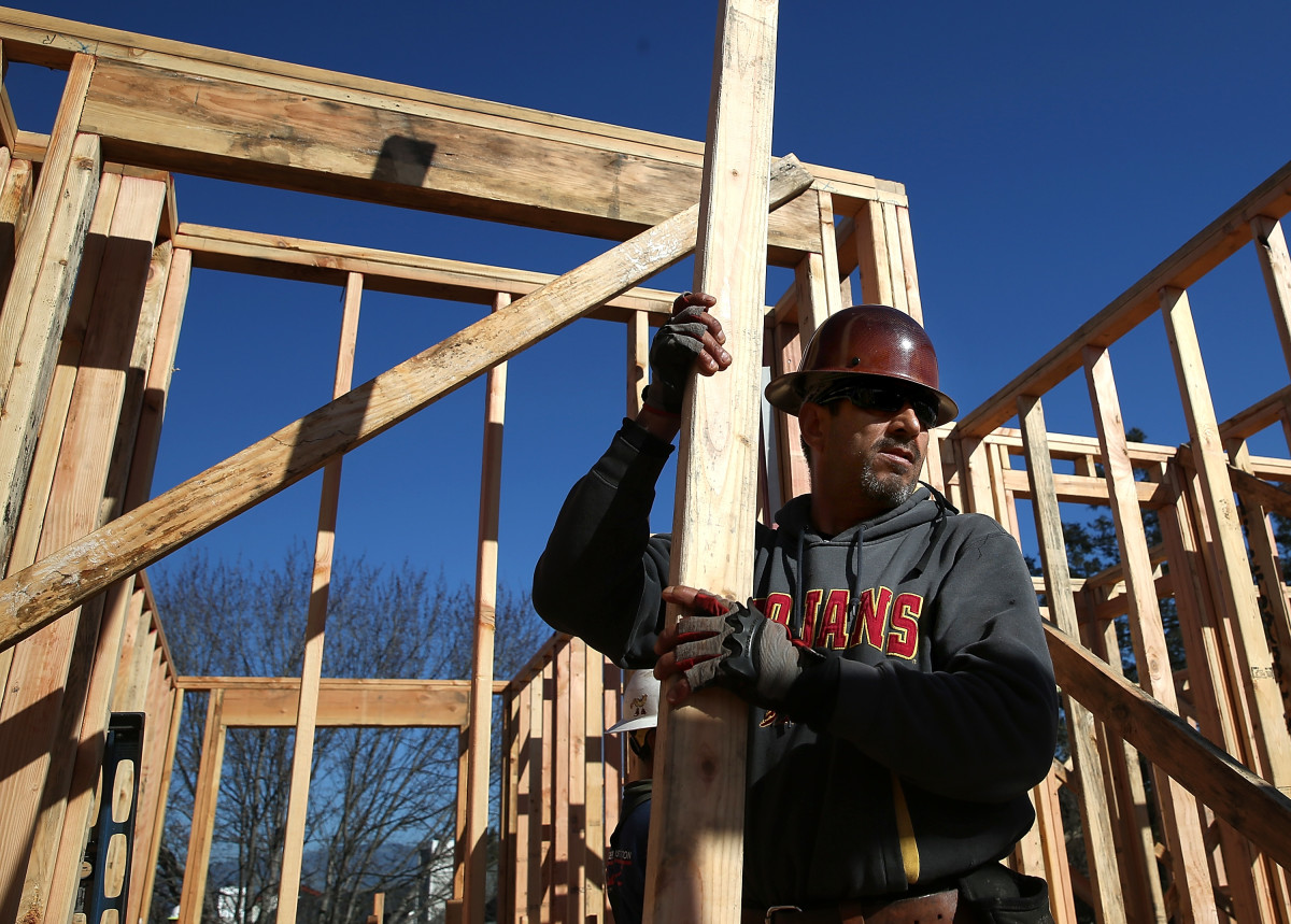 A worker carries lumber as he builds a new home on January 21st, 2015, in Petaluma, California.