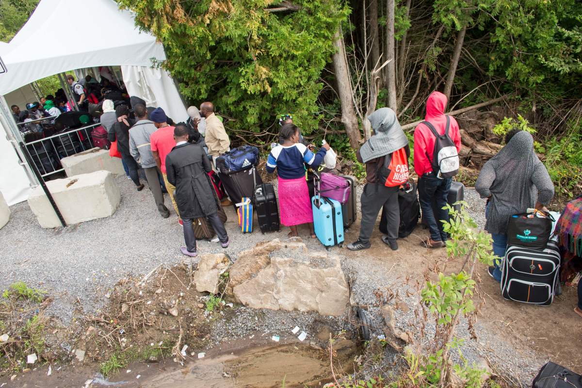 A long line of asylum seekers wait to illegally cross the Canada/U.S. border.