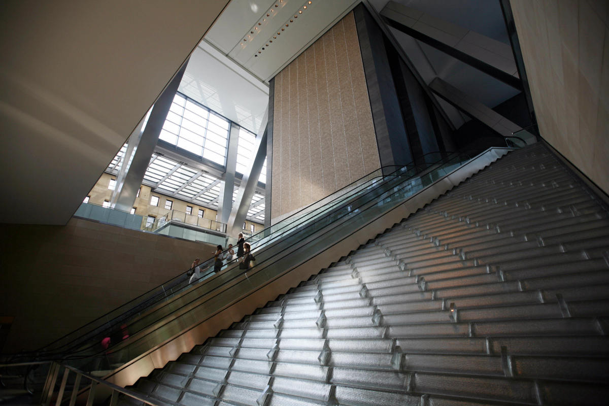 Office workers ride an escalator in the lobby of the Hearst Tower, the first building in New York to get LEED certification.