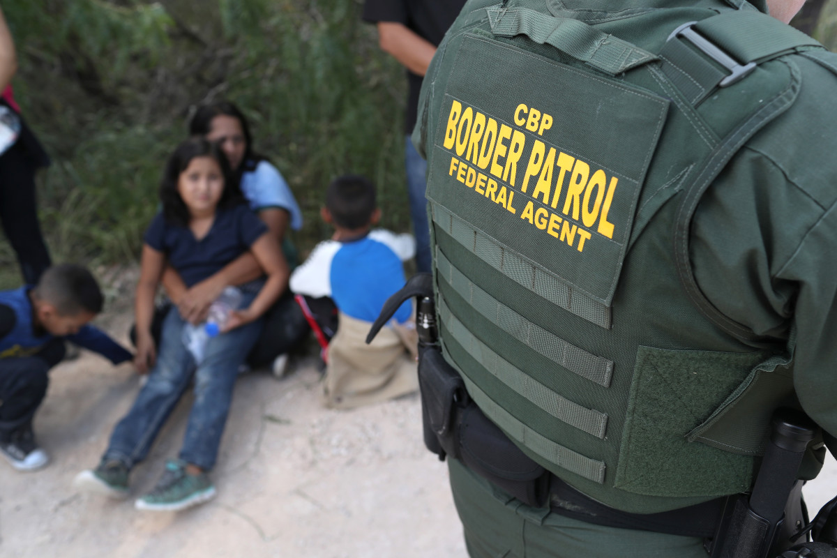 Central American asylum seekers wait as U.S. Border Patrol agents take them into custody on June 12th, 2018, near McAllen, Texas.