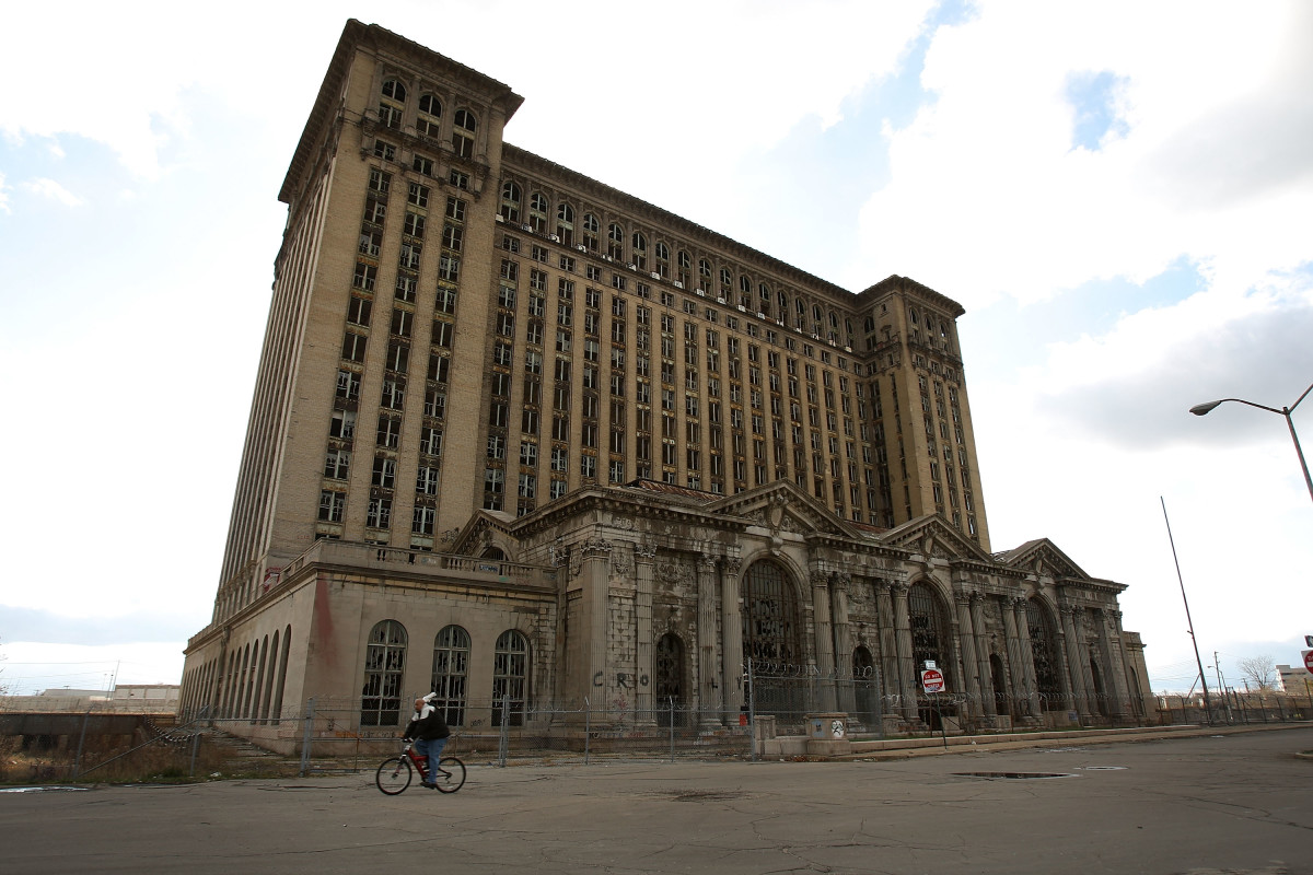A man rides his bike past the shuttered Michigan Central Railroad Station November 20th, 2008, in Detroit, Michigan.