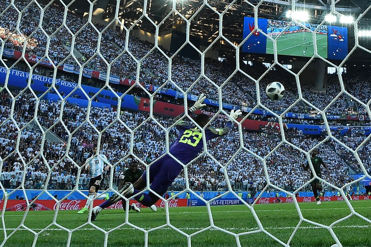 Argentina's forward Lionel Messi (L) shoots to score during the Russia 2018 World Cup Group D football match between Nigeria and Argentina at the Saint Petersburg Stadium in Saint Petersburg on June 26th, 2018. Argentina ultimately beat Nigeria 2–1, advancing to the round of 16.