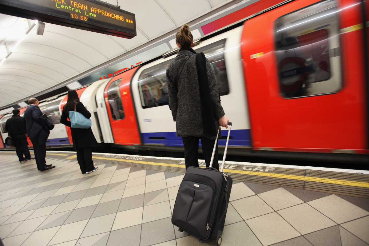 Commuters wait for a train at a London Underground station.