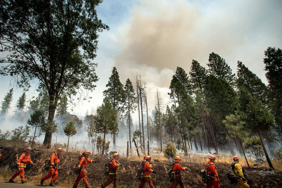 Inmate firefighters battle the Ferguson fire in Jerseydale, California, on July 22nd, 2018. A fire that claimed the life of one firefighter and injured two others near California's Yosemite National Park has almost doubled in size in three days, authorities said Friday. The U.S. Department of Agriculture said the so-called Ferguson fire had spread to an area of 22,892 acres, and was so far only 7 percent contained.