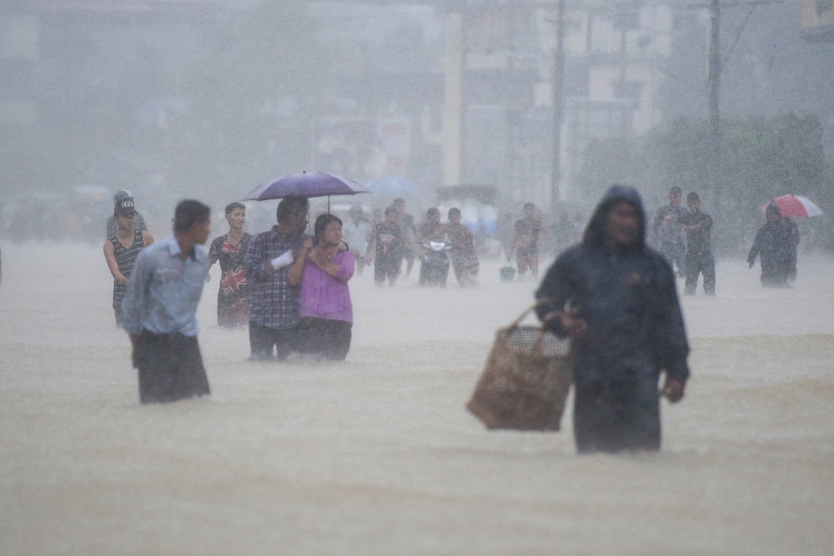Residents walk in floodwaters in the Bago region on July 29th, 2018.