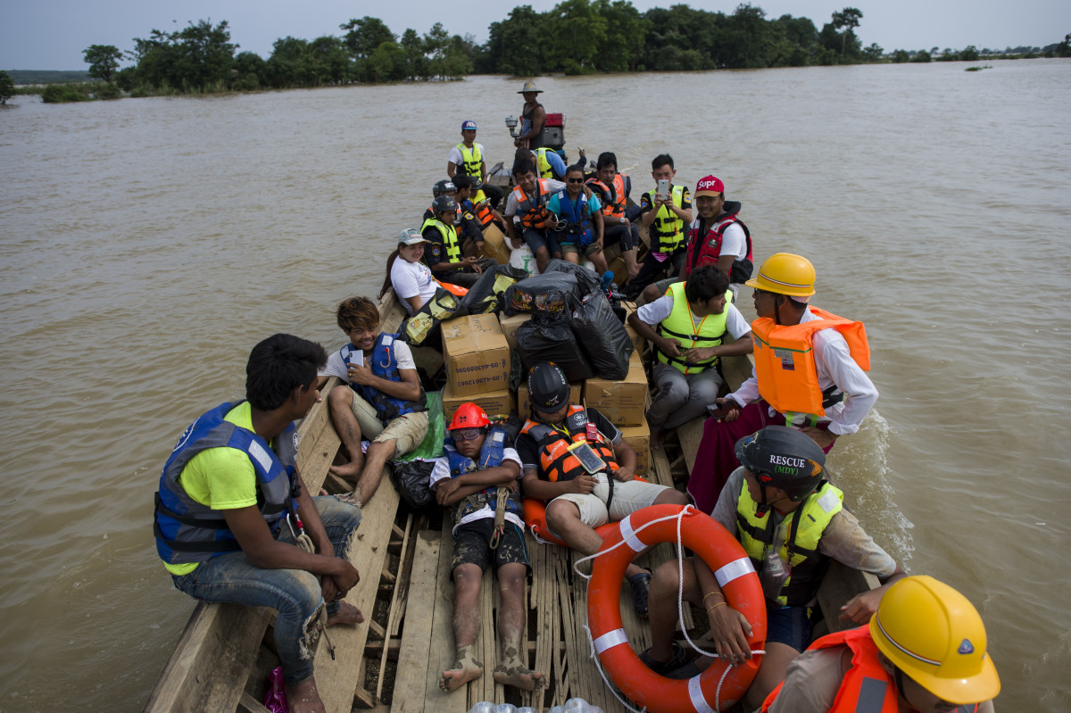 Volunteers with relief goods travel on floodwaters in Shwegyin, Bago region, on August 1st, 2018.