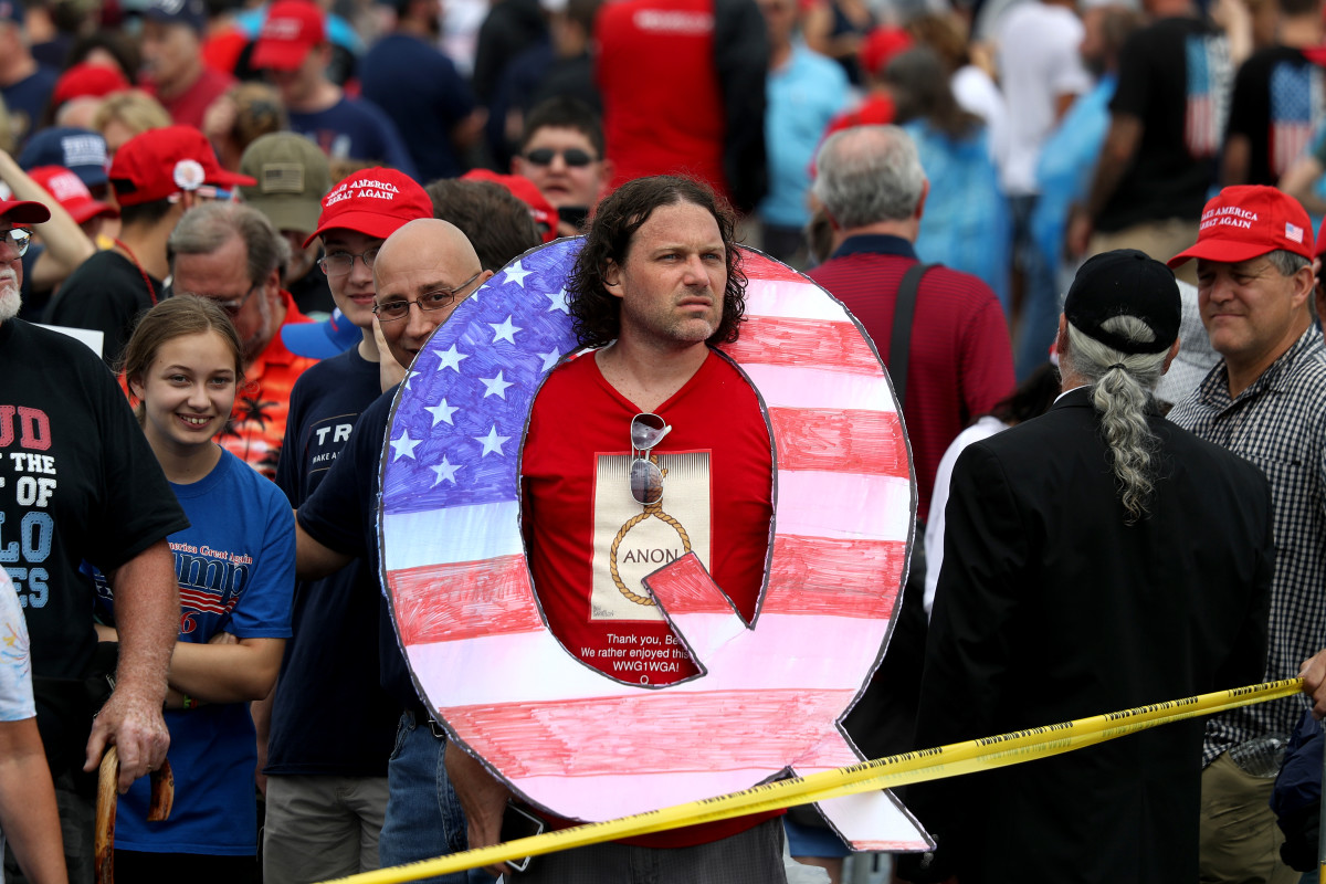 A man holds a large Q sign, referencing the Qanon conspiracy theory, at a rally for President Donald Trump on August 2nd, 2018, in Wilkes Barre, Pennsylvania.
