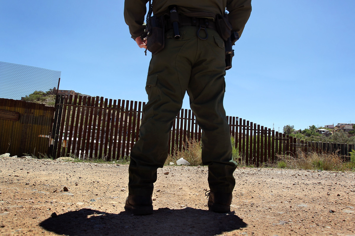 A U.S. Border Patrol agent stands near the border fence between the United States and Mexico in Nogales, Arizona.