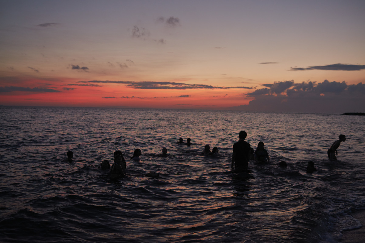 Teenagers play in sunset surf along the southern tip of Tangier Island.