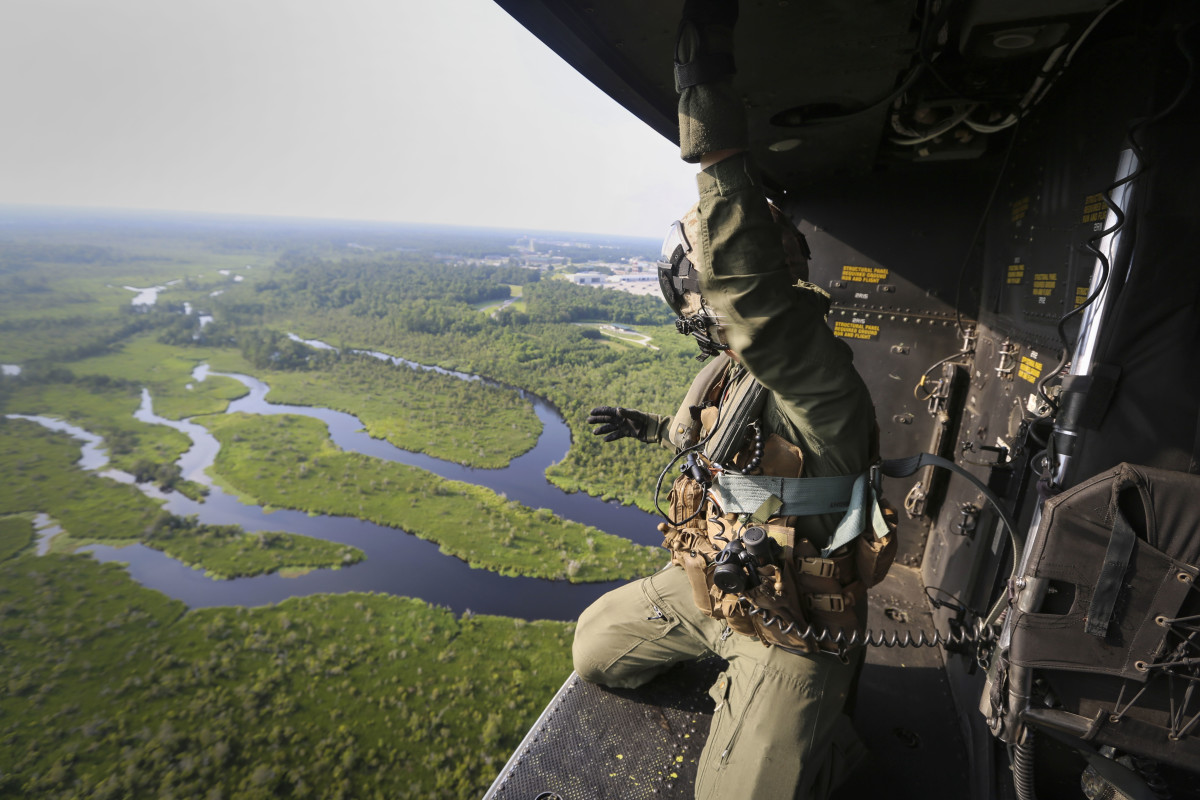 A crew chief with Marine Light Attack Helicopter Squadron 167, 2nd Marine Aircraft Wing, rides in the back of a UH-1Y Venom as it approaches a landing zone during a training exercise near Camp Lejeune, North Carolina, on June 17th, 2016.