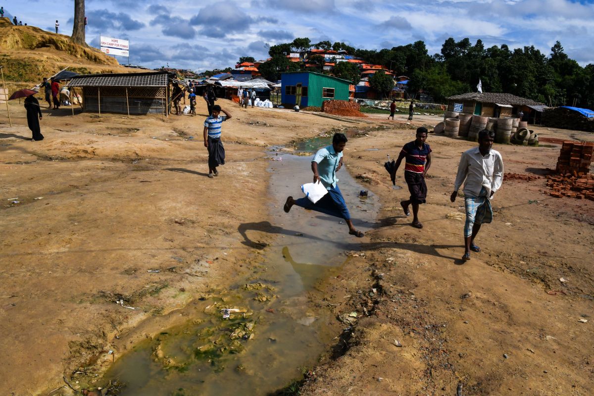A Rohingya refugee jumps a puddle at Kutupalong refugee camp in Ukhia on August 14th, 2018. The United Nations has described the army purge against the persecuted minority as ethnic cleansing, and thousands of Rohingya Muslims were believed to have been slaughtered in the pogrom that began last August.
