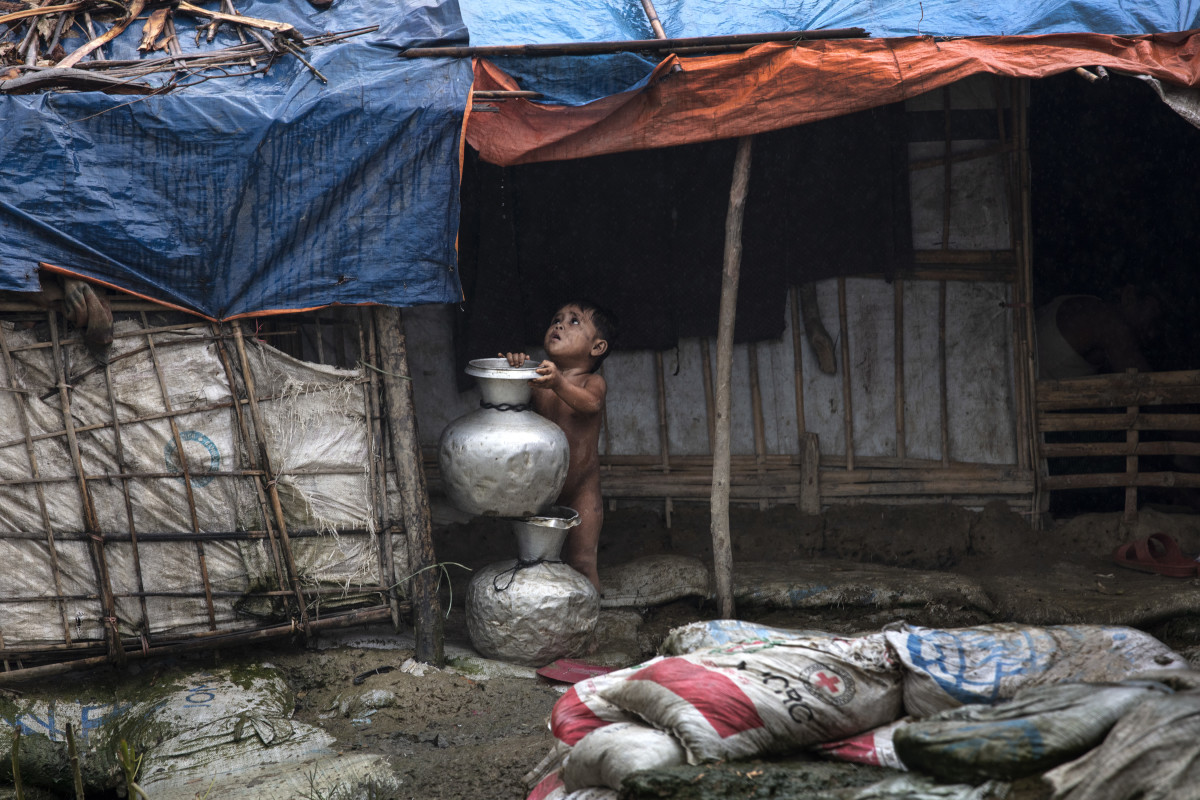 A young child stands under a shelter as monsoon rains hit on August 28th, 2018, in Unchiprang refugee camp, Cox's Bazar, Bangladesh. Tuesday marked the one-year anniversary since a wave of violence forced more than 720,000 Rohingya to flee into the Cox's Bazar district. United Nations investigators said on Monday that Myanmar's army had carried out genocide against the Rohingya in Rakhine state, and that its top military figures must be investigated for crimes against minorities across the country. The U.N. report accused Myanmar's military of murders, imprisonments, enforced disappearances, torture, rape, and other forms of sexual violence in Rakhine state, all of which constitute crimes against humanity.