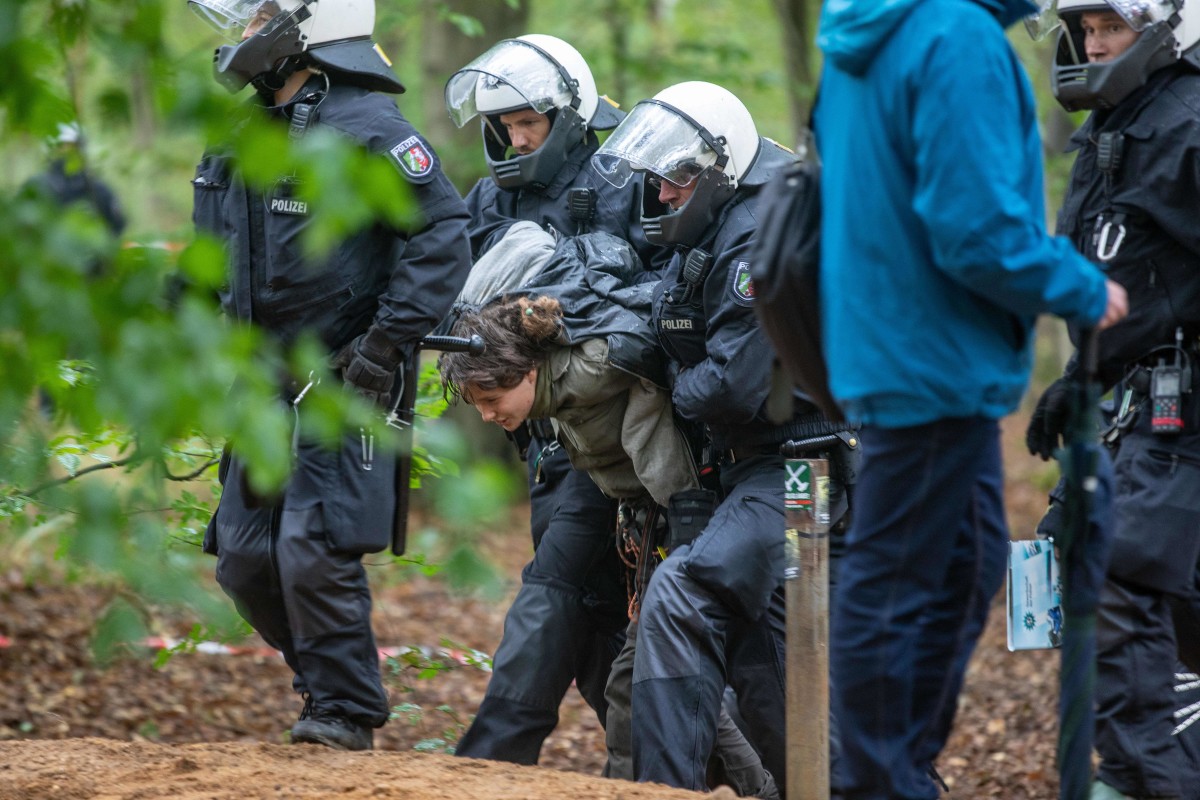 Policemen lead an environmental activist off the Hambach Forest on September 13th, 2018.