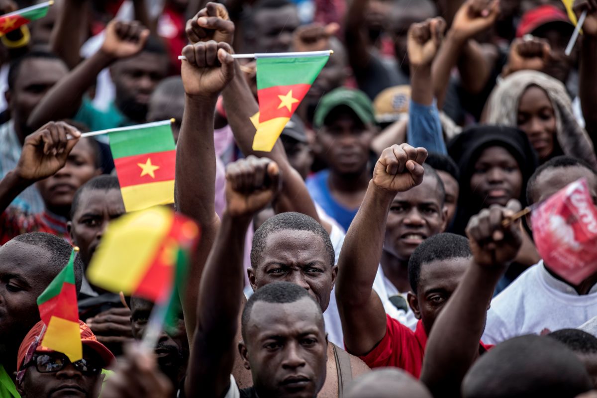 Supporters of the leader of the Cameroonian opposition party Movement for the Rebirth of Cameroon raise their fists during a campaign rally in Yaounde for the presidential elections.
