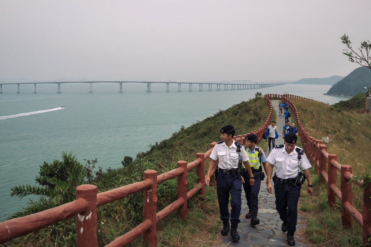 Police patrol ahead of Chinese President Xi Jinping's arrival for the official opening of the world's longest sea bridge on October 23rd, 2018, in Hong Kong. The bridge, which spans 34 miles, links Hong Kong, Macau, and Zhuhai on China'’s southern coast of Guangdong province, is set to open this week as part of Beijing'’s plan to merge 11 cities in its southern region into one megalopolis. Critics warn the bridge will increase China's influence over semi-autonomous Hong Kong.
