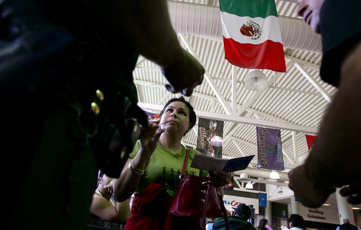 Members of the United States Border Patrol check a woman's identification at a Greyhound bus station in Phoenix, Arizona.