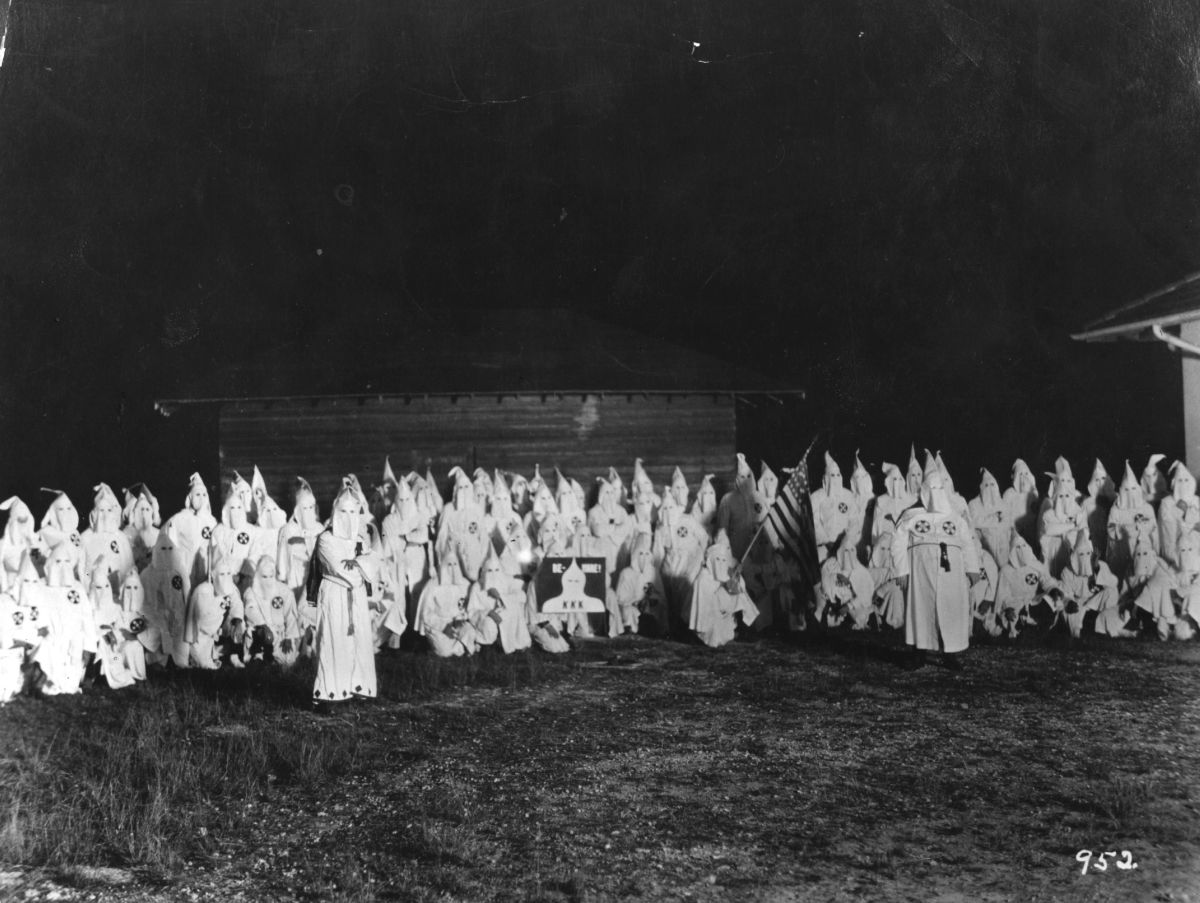 A meeting of hooded members of the Ku Klux Klan circa 1920.