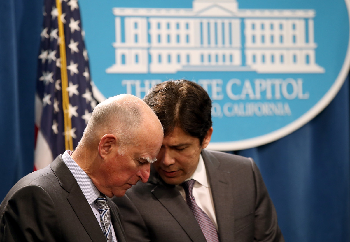 Jerry Brown and Kevin de León share notes during a news conference on March 19th, 2015, in Sacramento, California.