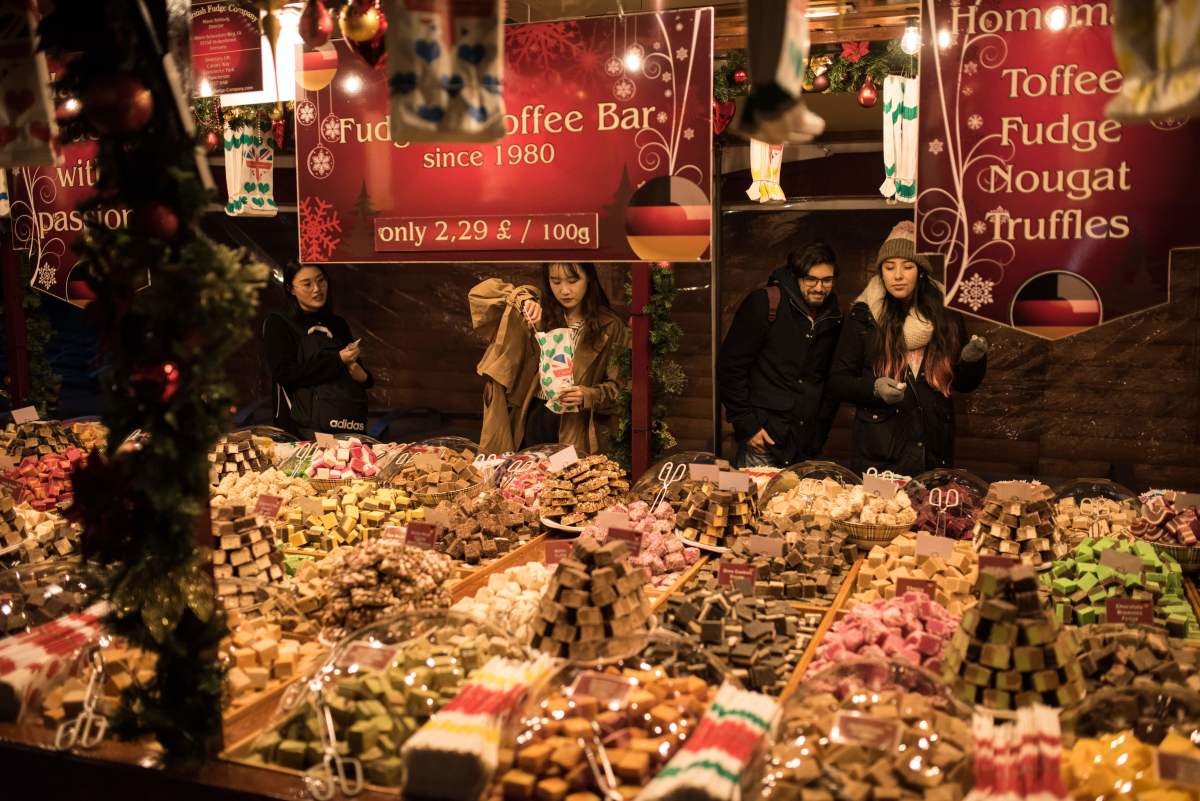 Shoppers purchase sweets from a stall at the Manchester Christmas Market, which is spread across the city center in Manchester, northern England, on November 9th, 2018.
