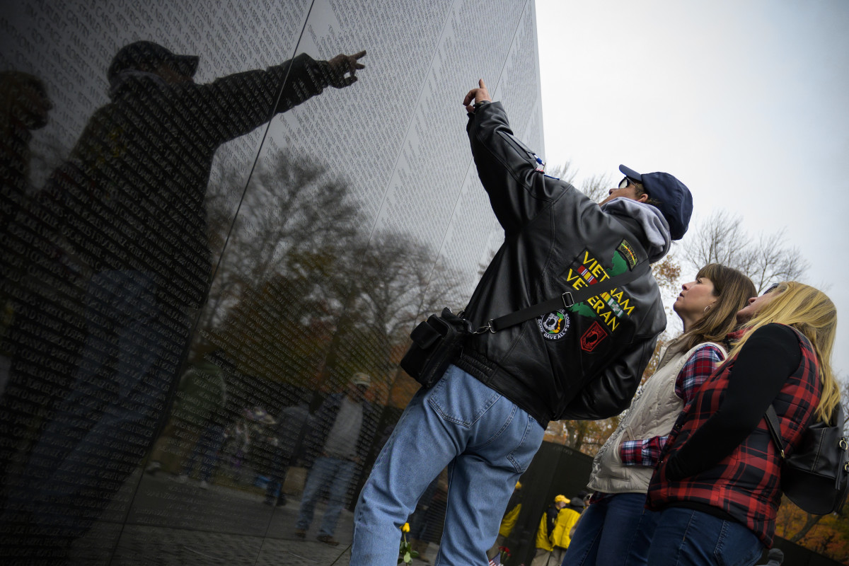 A Vietnam War veteran points to names of fallen soldiers on the wall of the Vietnam War Memorial in Washington, D.C., on November 12th, 2018.