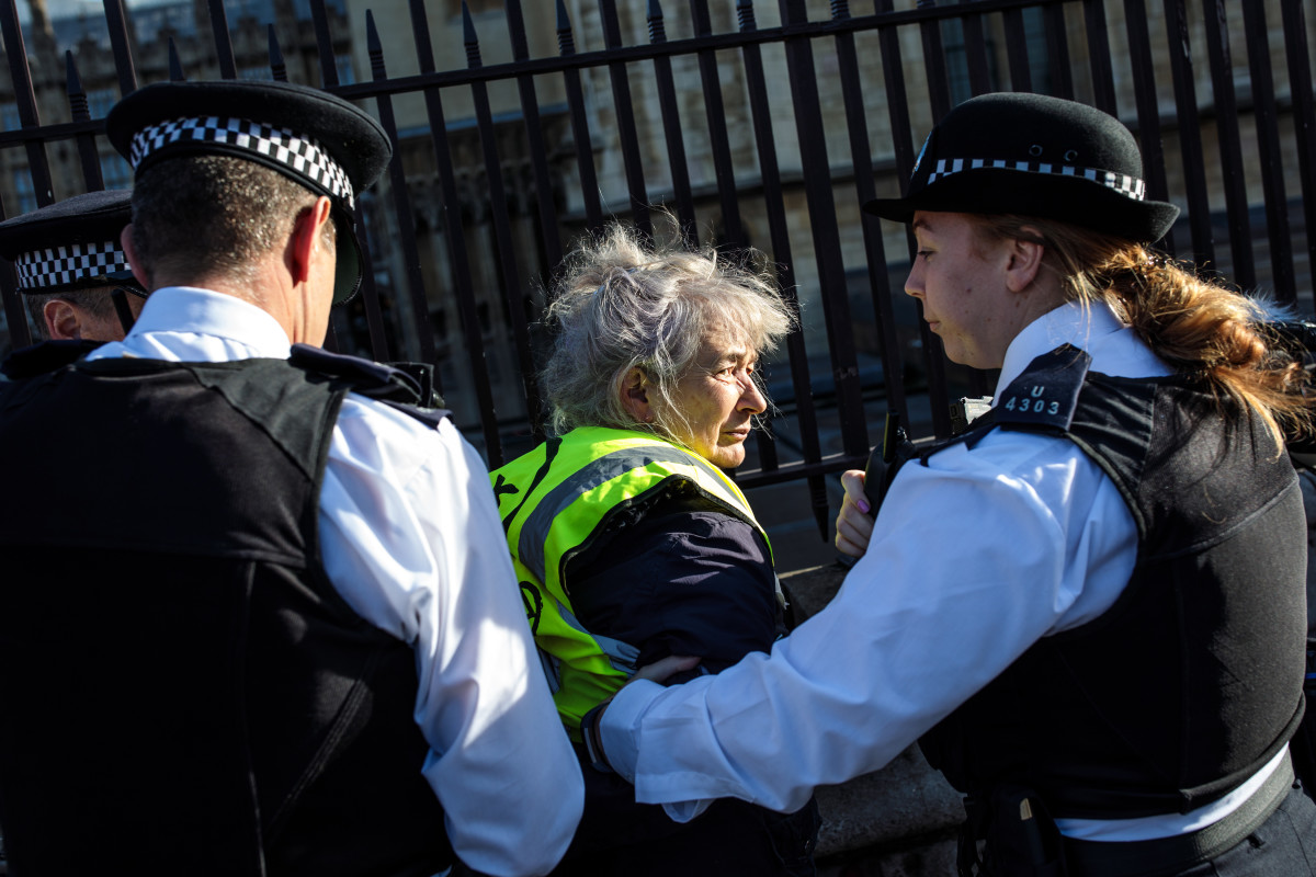 A climate activist is arrested after spray-painting on the gates outside the Houses of Parliament on November 14th, 2018, in London, England. Climate activist group Extinction Rebellion held a series of coordinated direct actions in Westminster, including writing "VEGAN SAVES US ALL" and "LOVE EACH OTHER" on the gates.