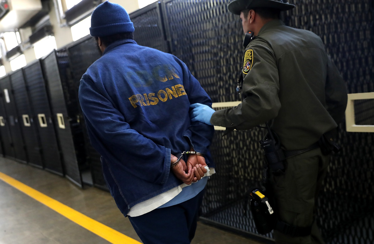 An armed California Department of Corrections and Rehabilitation officer escorts a condemned inmate at San Quentin State Prison on August 15th, 2016, in San Quentin, California.