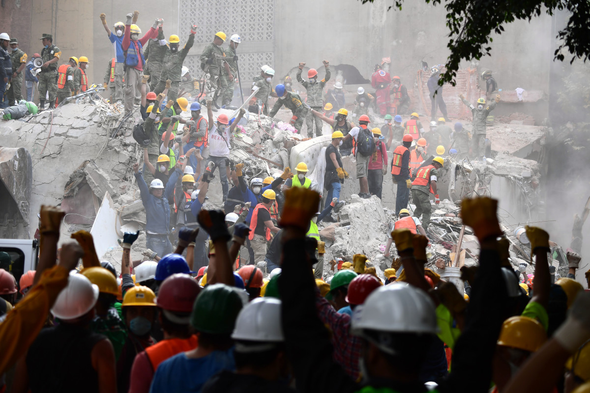Rescuers make the signal for silence during the search for survivors in a flattened building in Mexico City on September 21st, 2017, two days after a strong quake hit central Mexico.